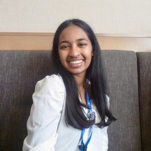 Diya Khetan sits and smiles at camera while in office space.
